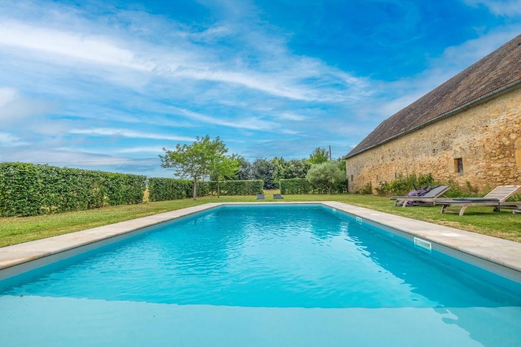 a swimming pool in a yard next to a building at La Bourgeoisie in Domme