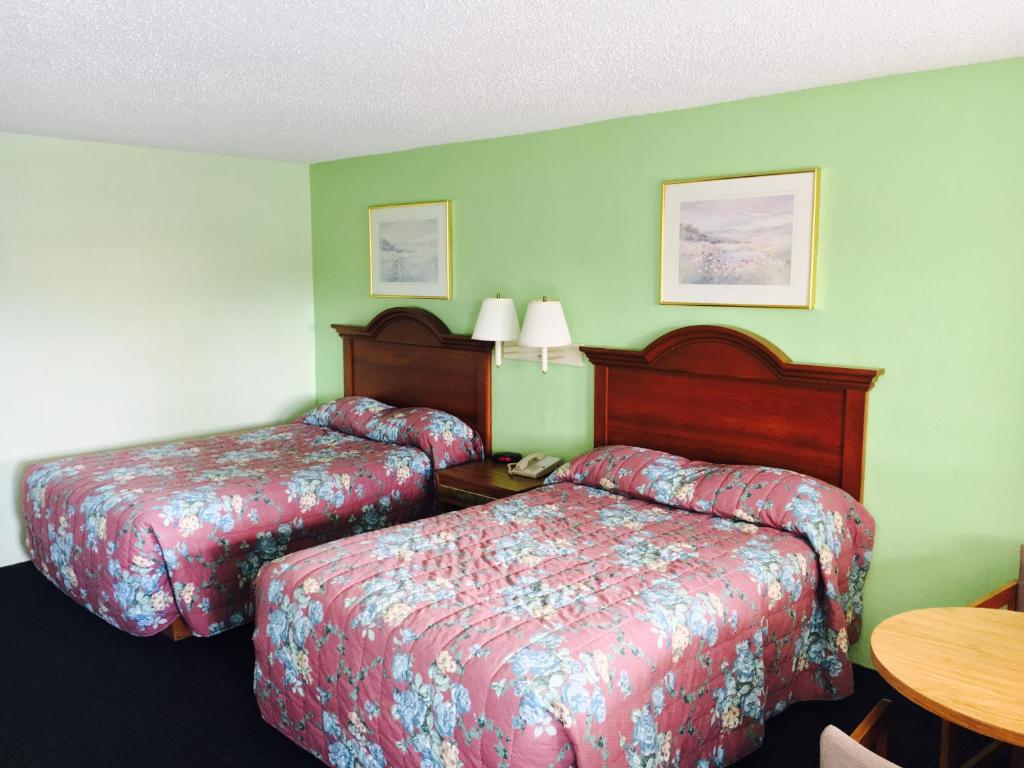 a hotel room with two beds and a table at Relax Inn in Folkston