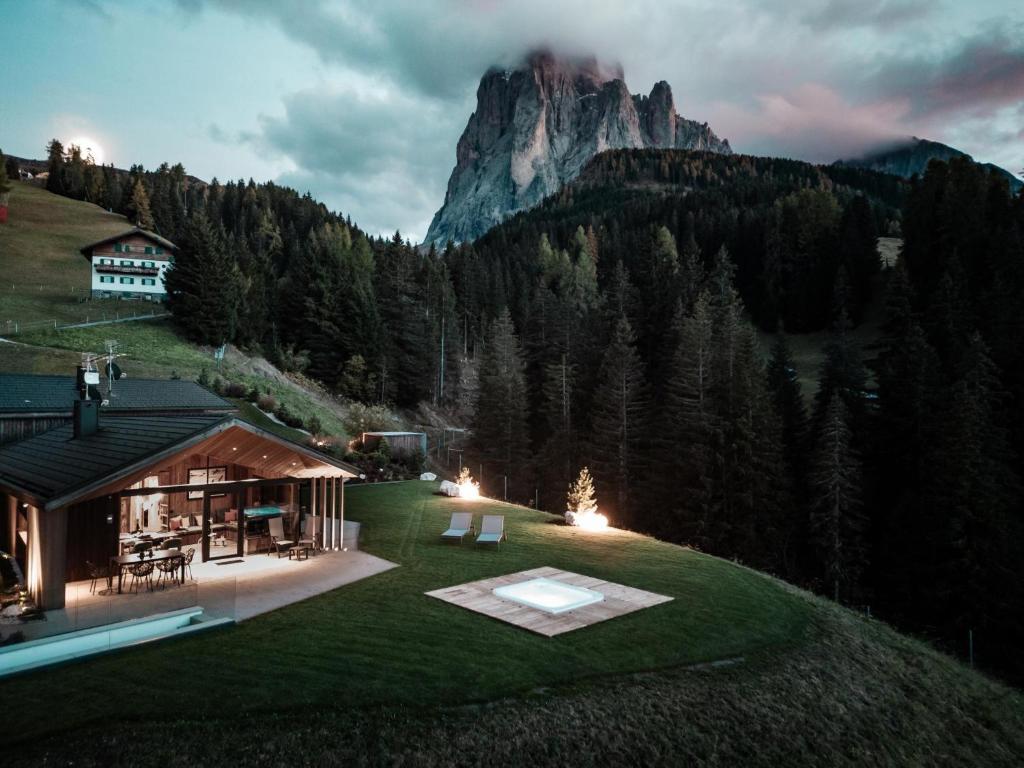 a house on a hill with a view of a mountain at Chalet Ski in Selva di Val Gardena