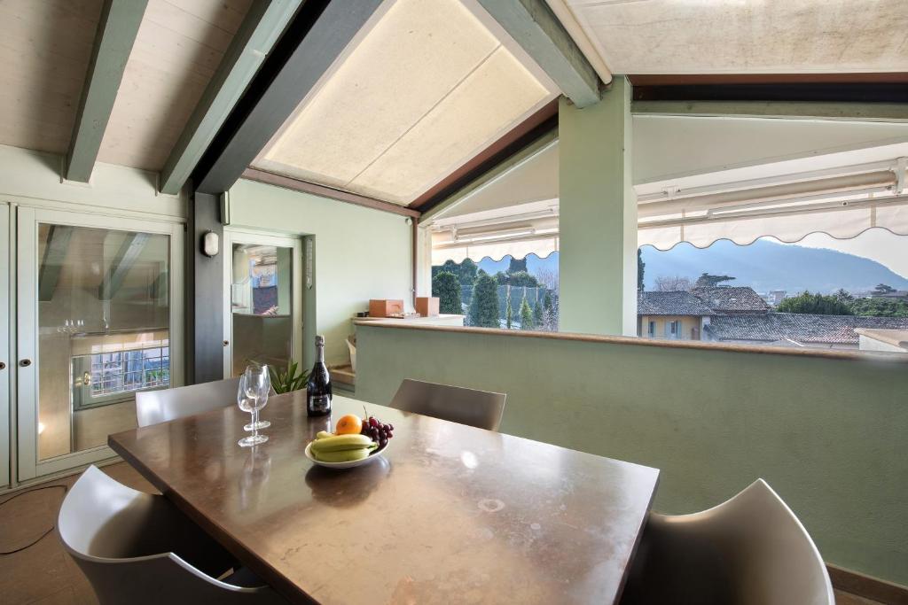 a dining room with a table and chairs and a window at Viasambuco in Iseo