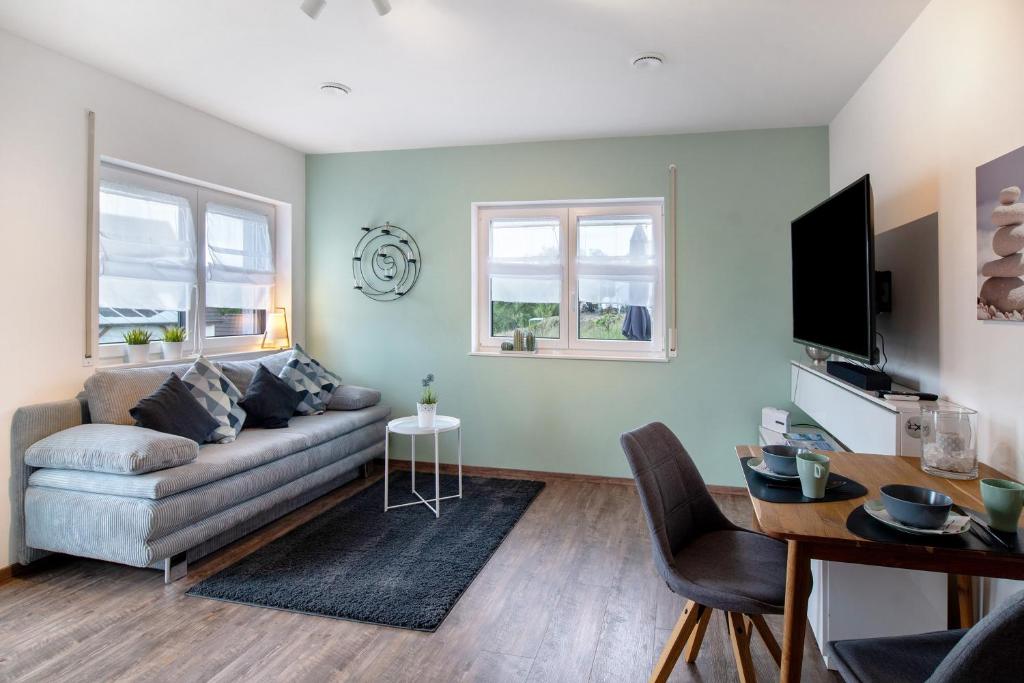 a living room with a couch and a table at Ferienwohnung mit eigenem Eingang in Deggenhausertal