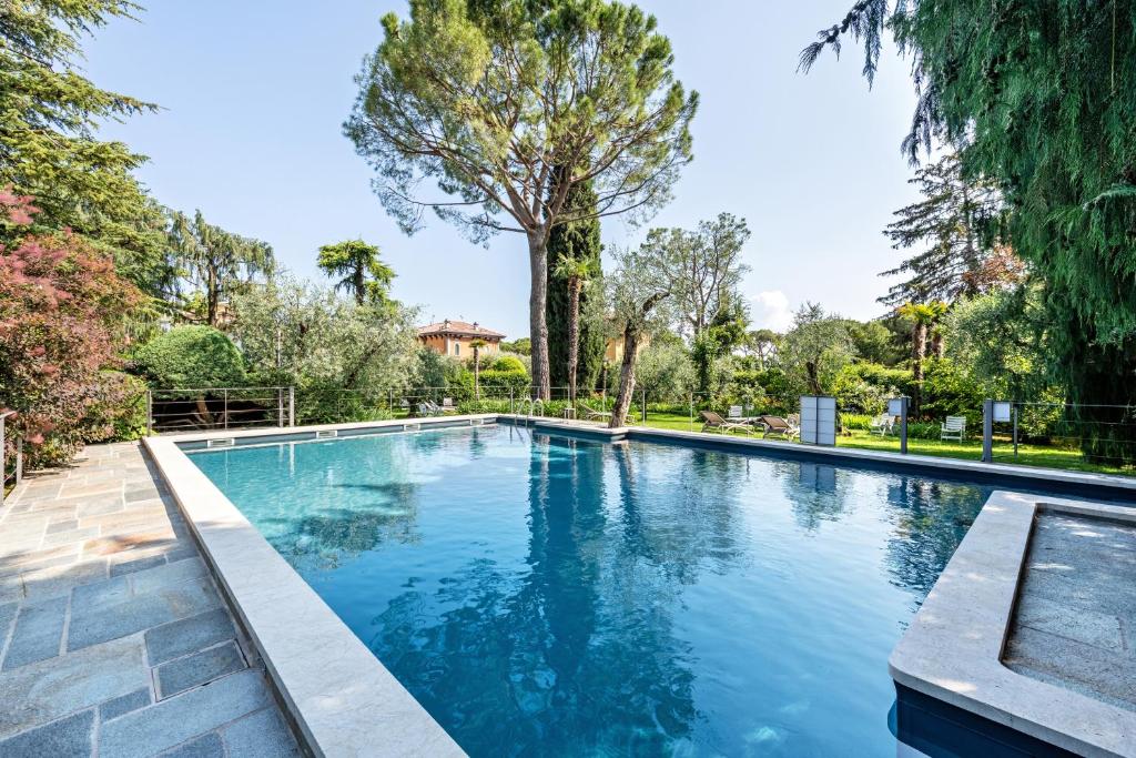 a swimming pool in a yard with trees at Al Segnavento Fasanella in Toscolano Maderno