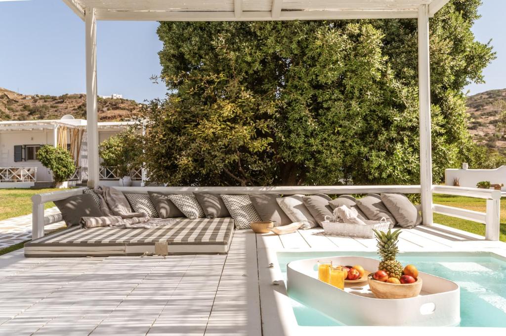 a patio with a couch and a bowl of fruit at Ow Andros Suite 2,Private Whirlpool in Andros