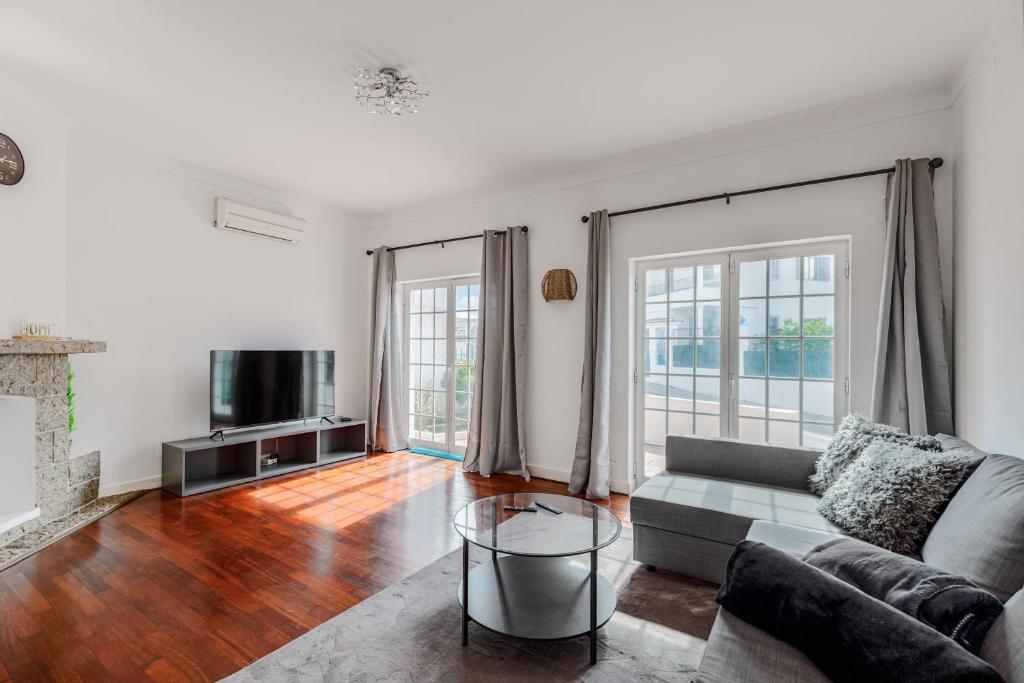 a living room with a couch and a tv at Alojamento Local Coruche Erra in Coruche