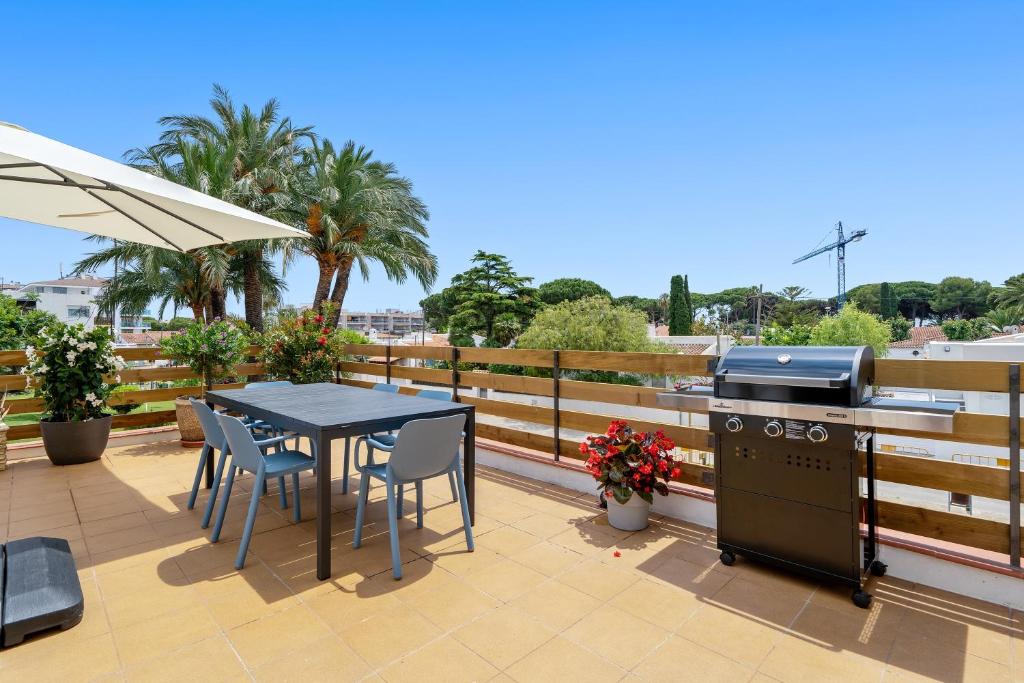 a table and chairs and a grill on a balcony at La Terrassa vistas al mar in Cambrils