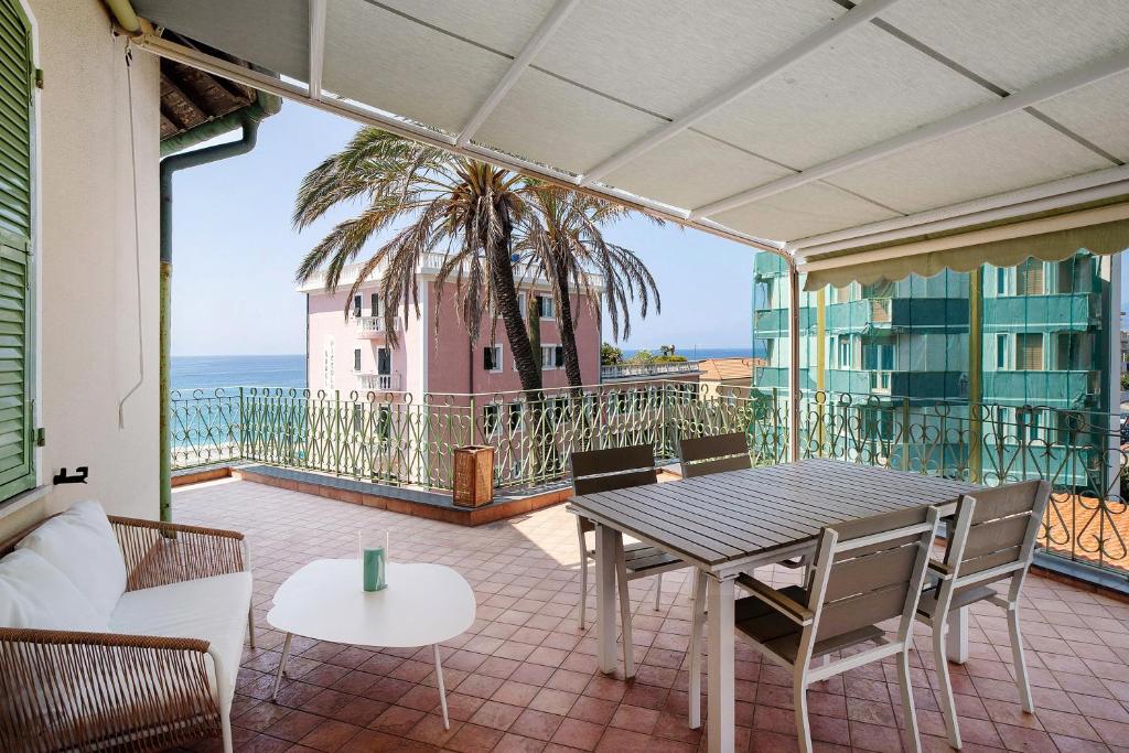 a patio with a table and chairs and the ocean at Wonderful flat by sea chez Monique in Bordighera
