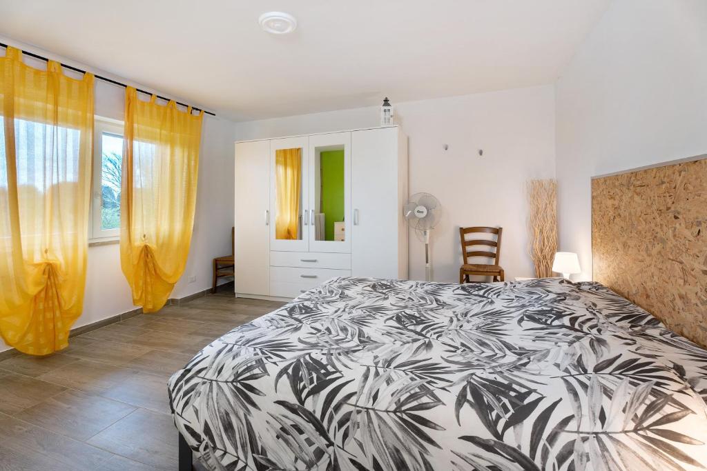 a bedroom with a black and white bed and yellow curtains at Sweet Home Apartments Bambù in Arona