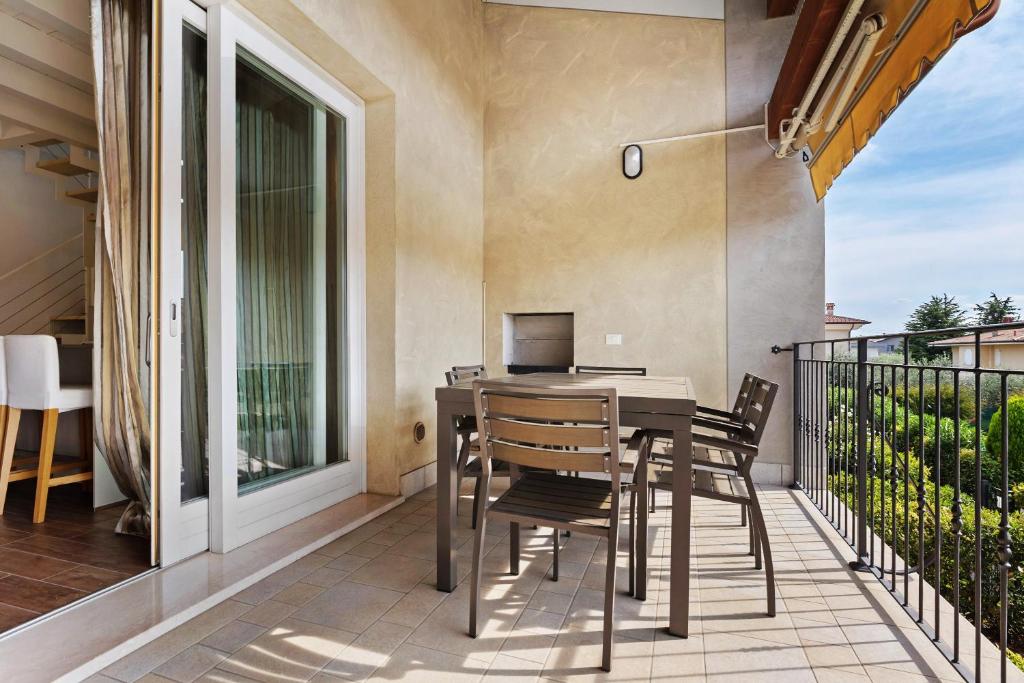 a patio with a table and chairs on a balcony at Appartamento Castello a Raffa in Puegnago