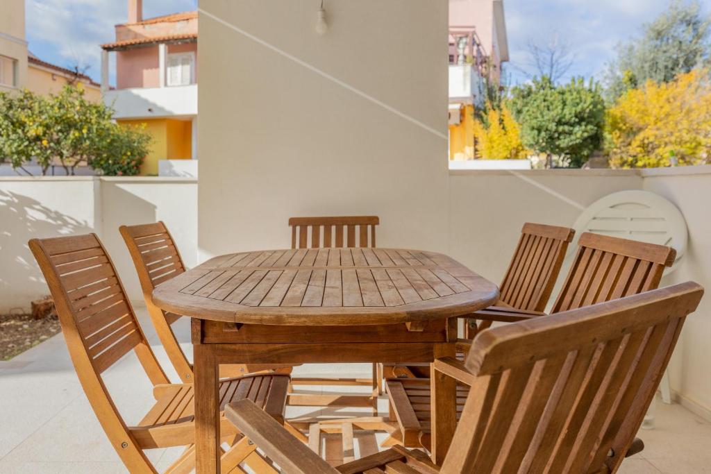 a wooden table and chairs on a patio at Cormorani - Appartamento 8 in Golfo Aranci