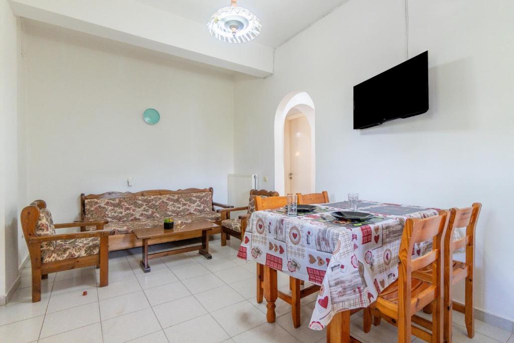 a living room with a table and chairs and a tv at Olivea Apt 1 in Acharavi