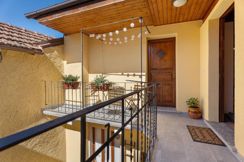 a house with a balcony with a wooden door at Il Vicolino in Pettenasco