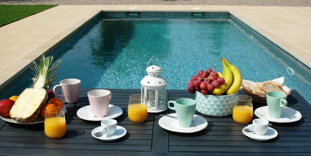 a table with fruit and juice next to a swimming pool at Son Pelai Menut in Lloseta
