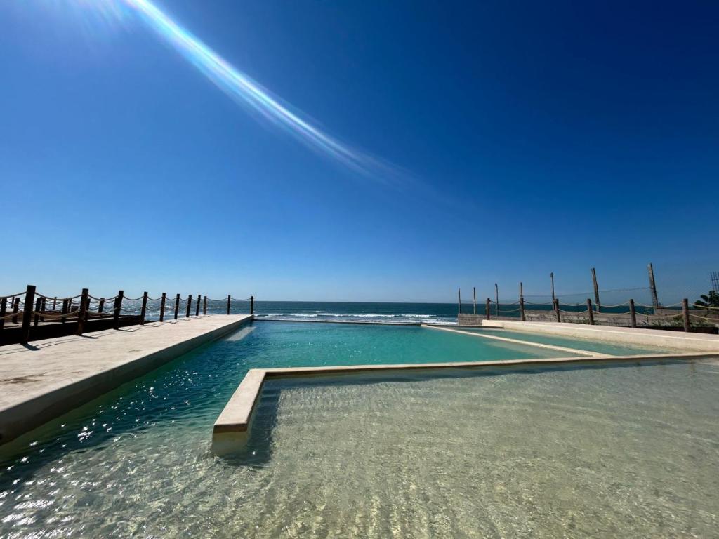 a pool of water next to the ocean at Hotel Calma Celesti in Perihuete