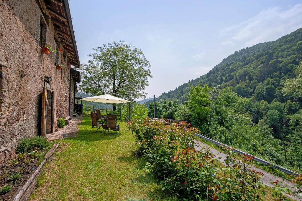 a patio with a table and an umbrella on the side of a building at Le Fratte in Pertica Alta