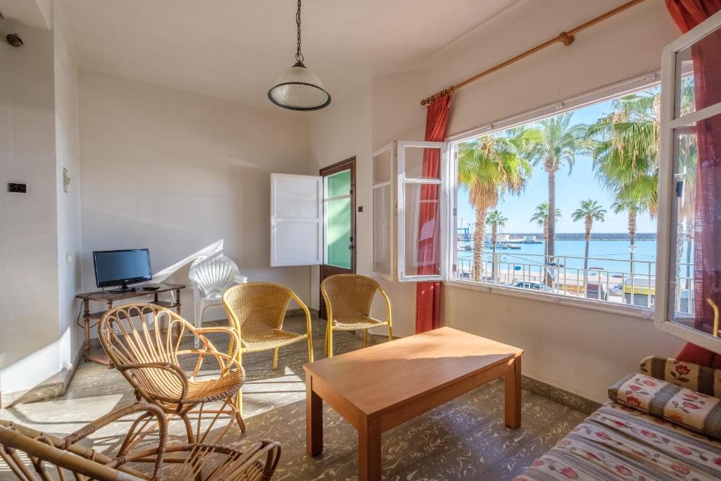 a living room with chairs and a table and a window at Apartamento las Palmeras 1 in Benicarló