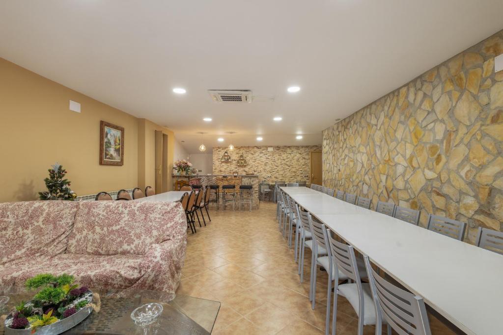 a room with a long bar with chairs and tables at El Ático in Maluenda