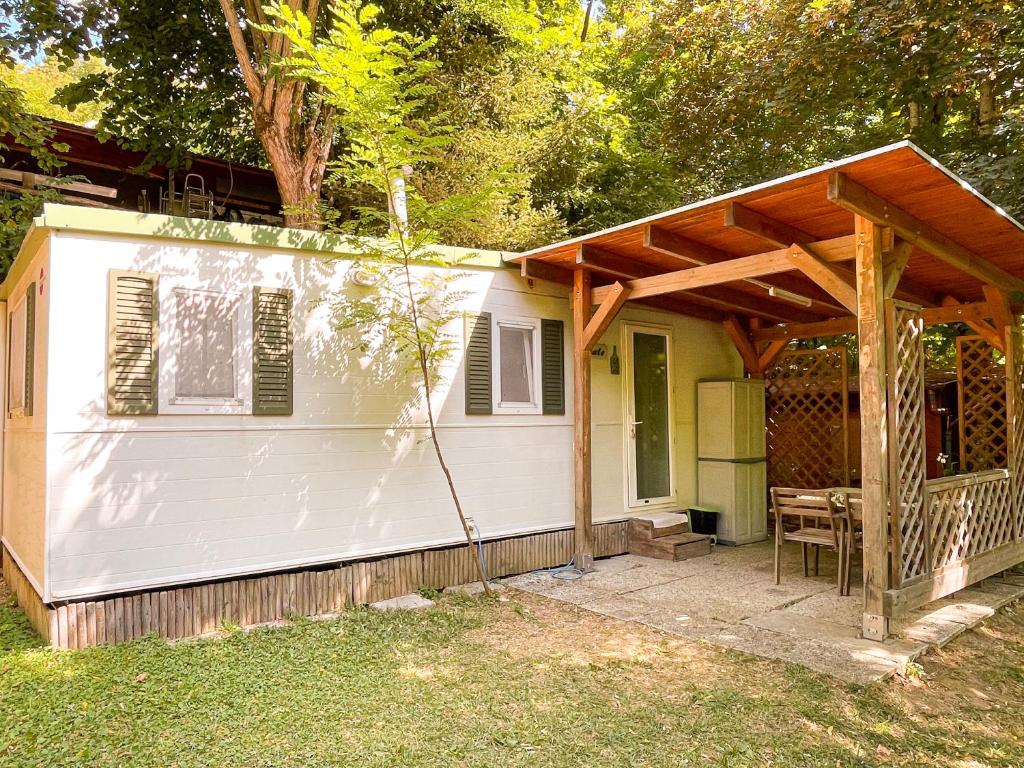 a small white house with a wooden roof at Le sorgenti - Mobile Home 46 in Palazzuolo sul Senio