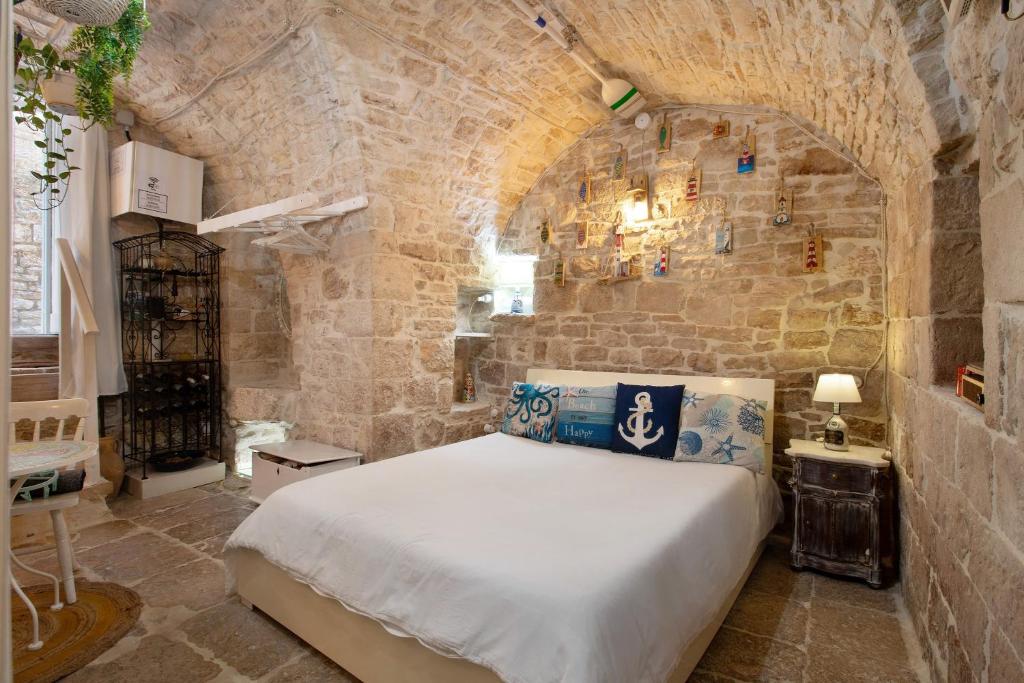 a bedroom with a large bed in a stone wall at La Cantina in Giovinazzo
