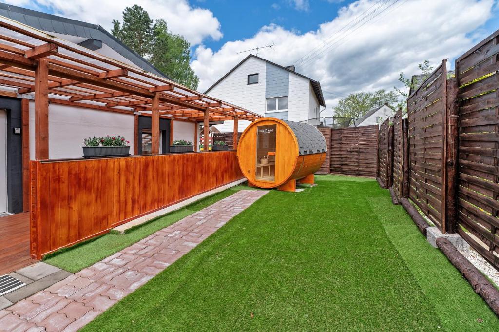 a backyard with a wooden fence and green grass at Haus Zum Stumpfen Turm mit Sauna in Morbach