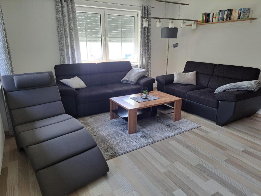 a living room with two couches and a coffee table at Ferienwohnung im Ries in Wallerstein
