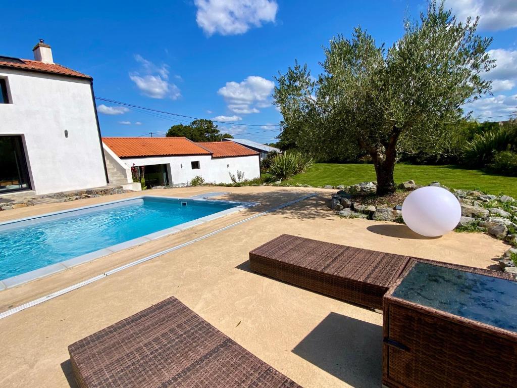 a villa with a swimming pool and a house at La Cour de la Forêt in Saint-Mars-de-Coutais