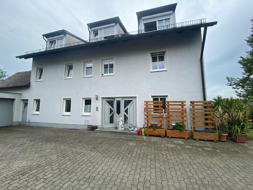 a white house with a dog in front of it at Apartment Wohner in Petersaurach