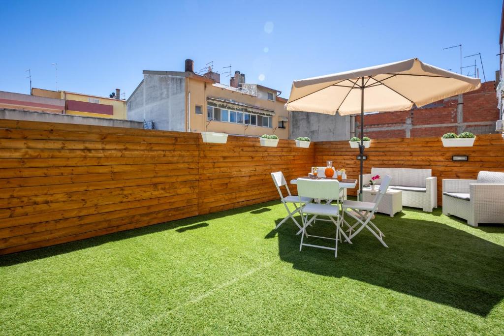 a patio with an umbrella and a table and chairs at Max Apartment in Quartu SantʼElena