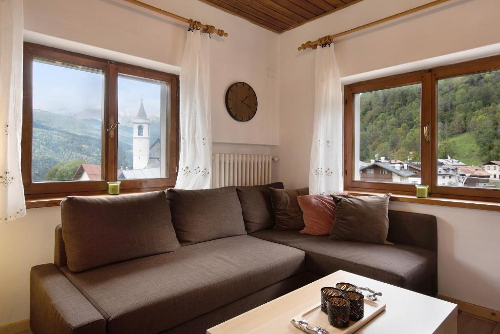 a living room with a couch and two windows at Casa de Lorenzo in Vodo Cadore