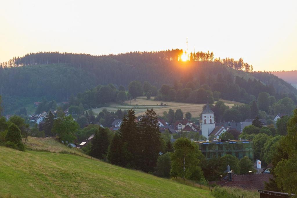 a small town on a hill with the sunset in the background at Ferienwohnung Wälderliebe in Lenzkirch