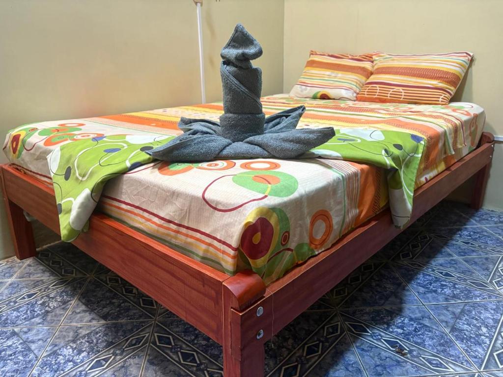a bed with a cat sitting on top of it at La Lagartija Iquitos in Iquitos