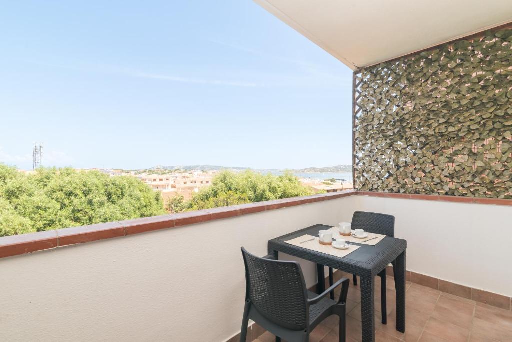 a table and chairs on a balcony with a large window at La Gioia in Palau