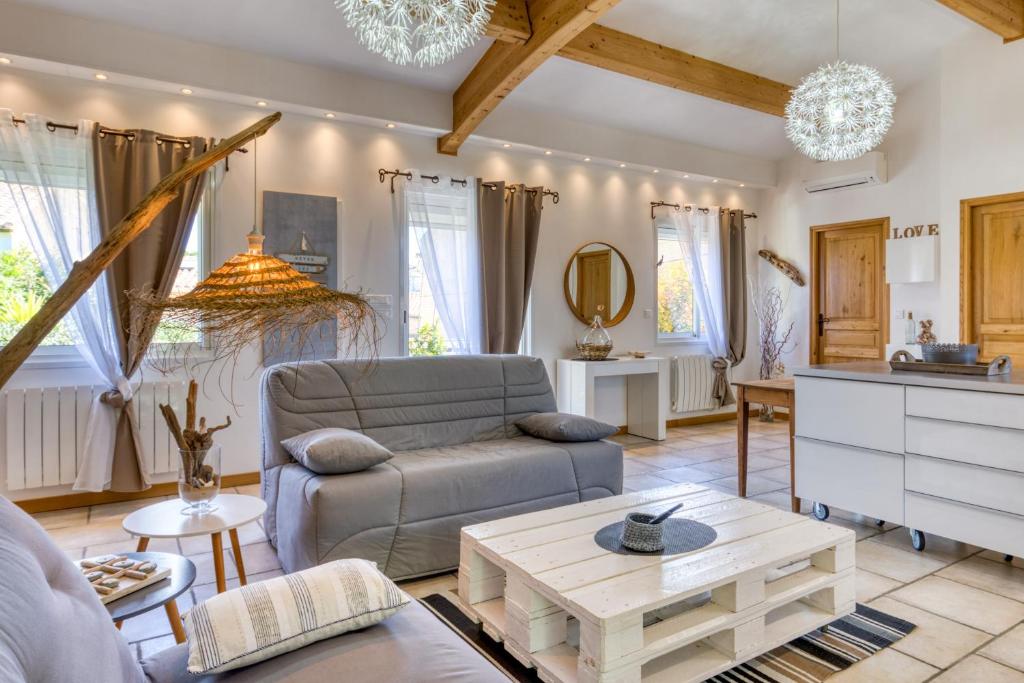 a living room with a couch and a table at Les Bois flottés in Poussan