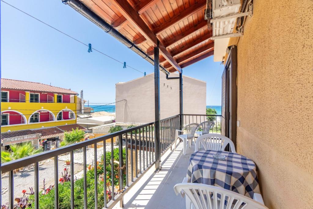 a balcony with a table and chairs and a view of the ocean at Mires House Apartment 11 in Agios Gordios