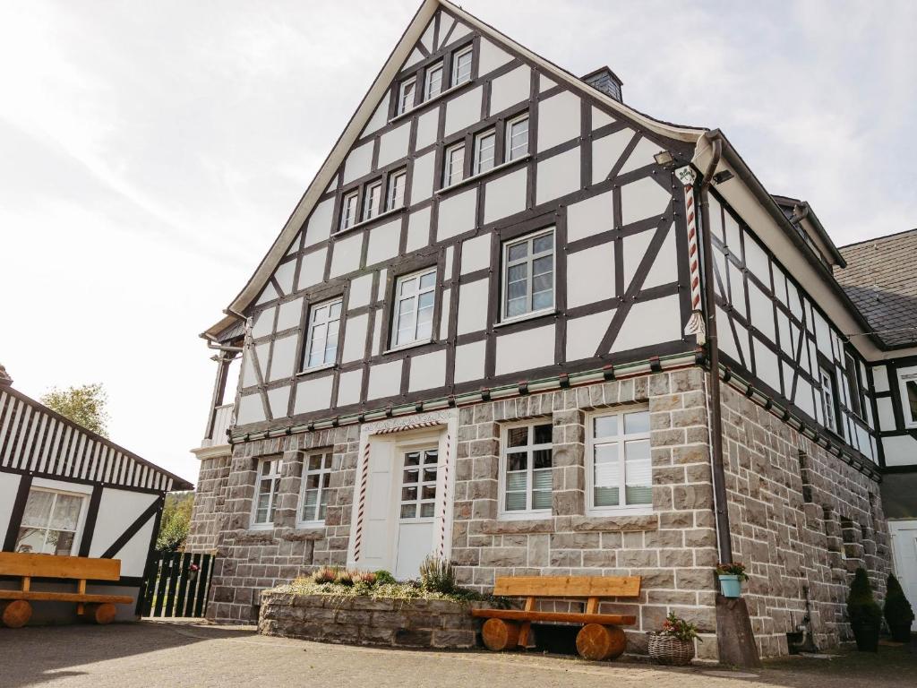 a black and white building with a bench in front of it at Ferienwohnung Wennetal in Schmallenberg