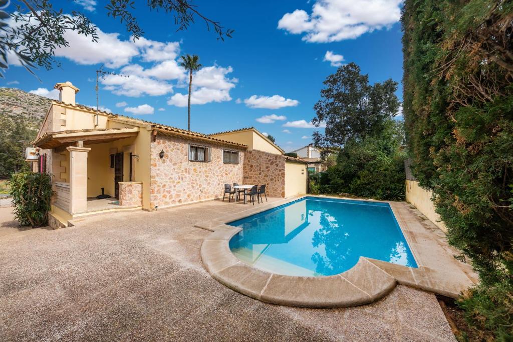 a villa with a swimming pool in front of a house at Casa Isabel y Mateo in Cala de Sant Vicenc