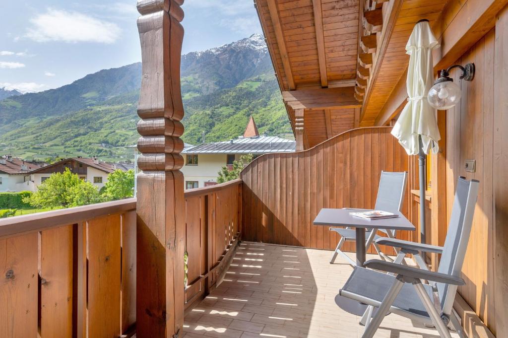 a wooden balcony with a desk and a chair on it at Mayr Apartments sechs in Plaus