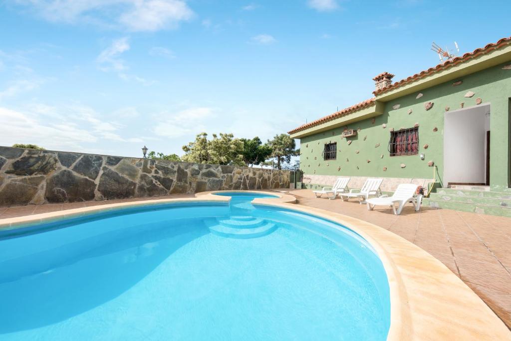a swimming pool in front of a house at Finca Aramai in Adeje