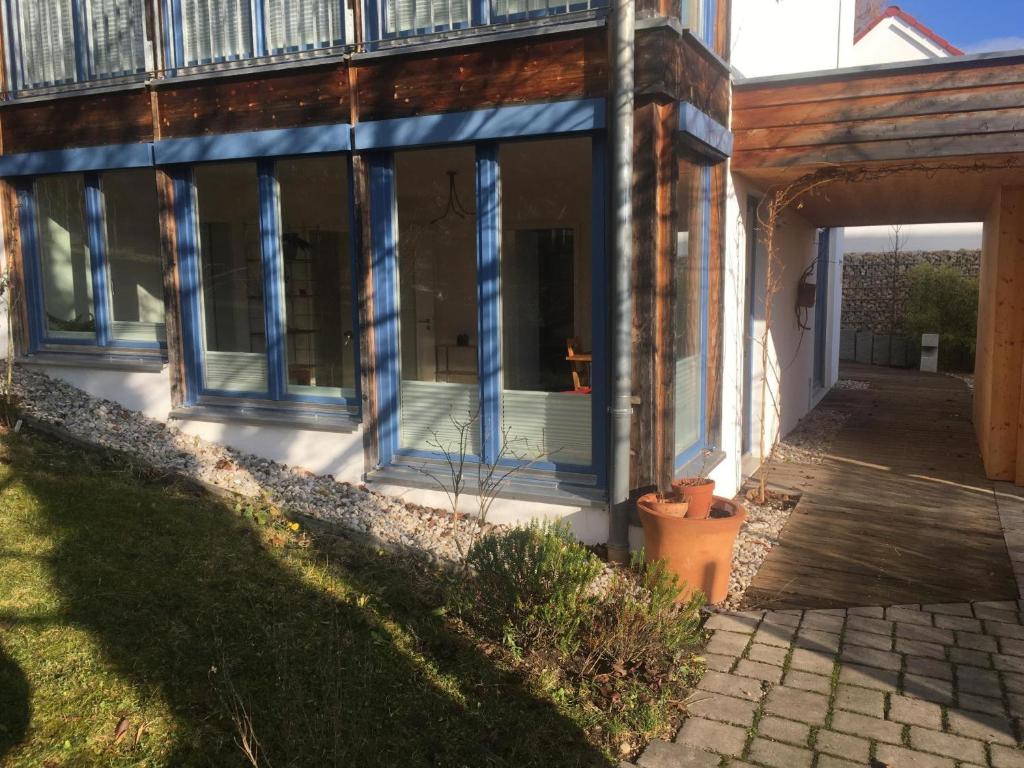 a house with blue windows and a porch at Atelierwohnung Bei München in Pfaffenhofen an der Ilm