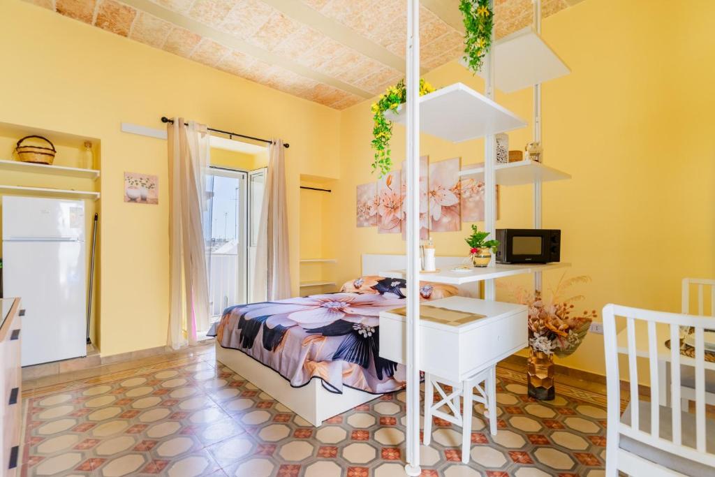 a bedroom with a bed and a desk in a room at Casa donna Sofia in Specchia