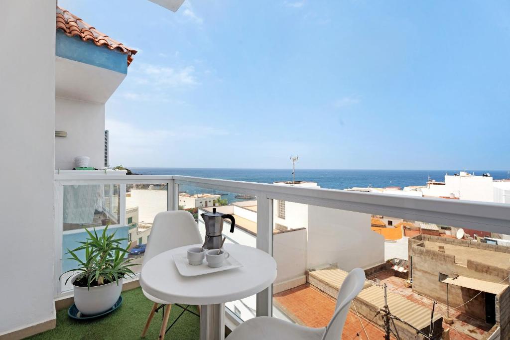 a balcony with a table and chairs and the ocean at Alcamar in Alcalá