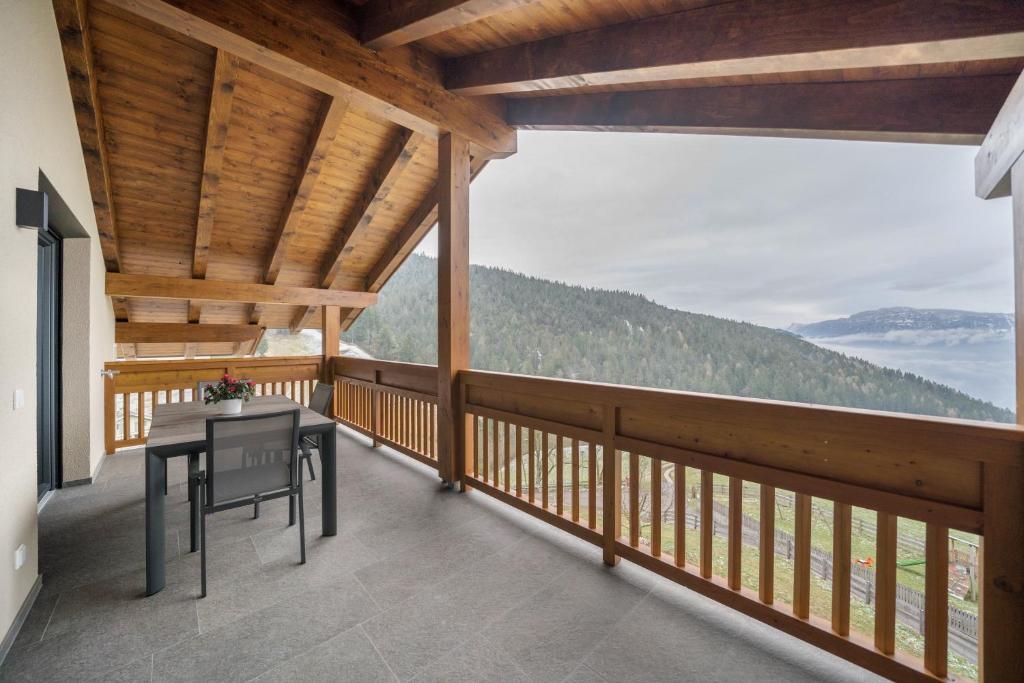 a balcony with a table and a view of the mountains at Parliflhof Apt Langfenn in Meltina