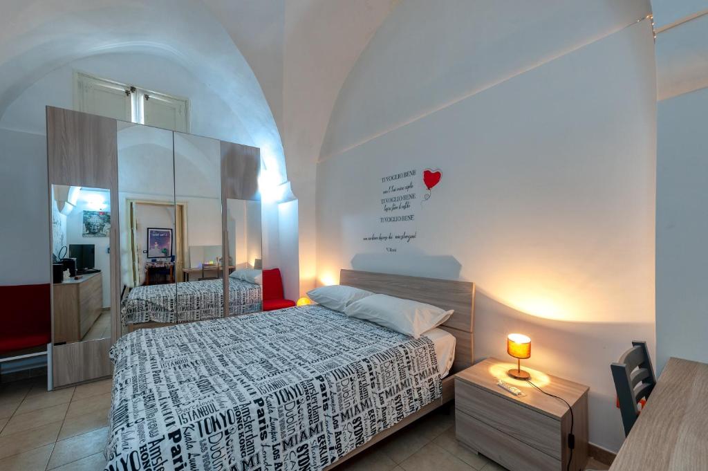 a small bedroom with a bed and a mirror at Dimora storica monteroni di lecce in Monteroni di Lecce