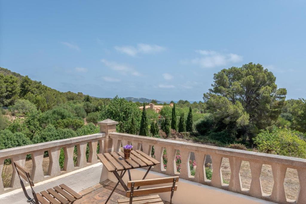 a wooden table and chairs on a balcony with trees at Can Cancus in Capdepera