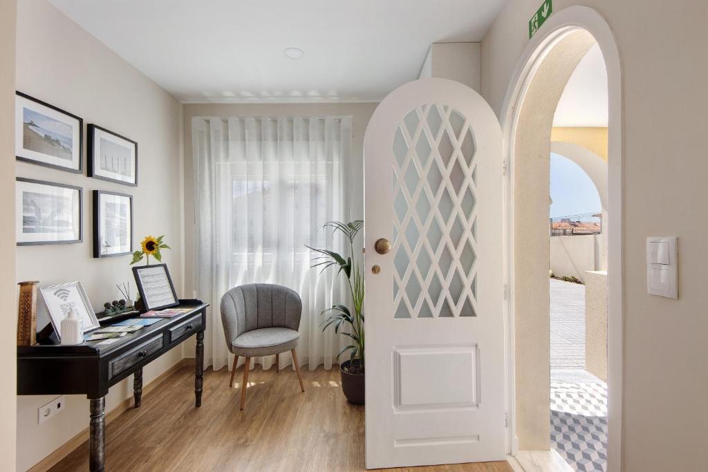 an archway leading into a home office with a piano at Pontes Guest House in Arcozelo