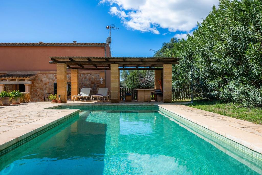 a swimming pool in front of a house with a gazebo at Ses Oliveres en Port Verd in Son Servera