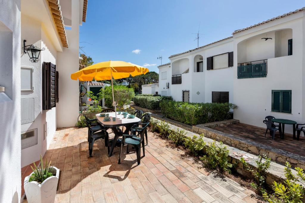a patio with a table and chairs and an umbrella at Villa Isabel in Vale do Lobo
