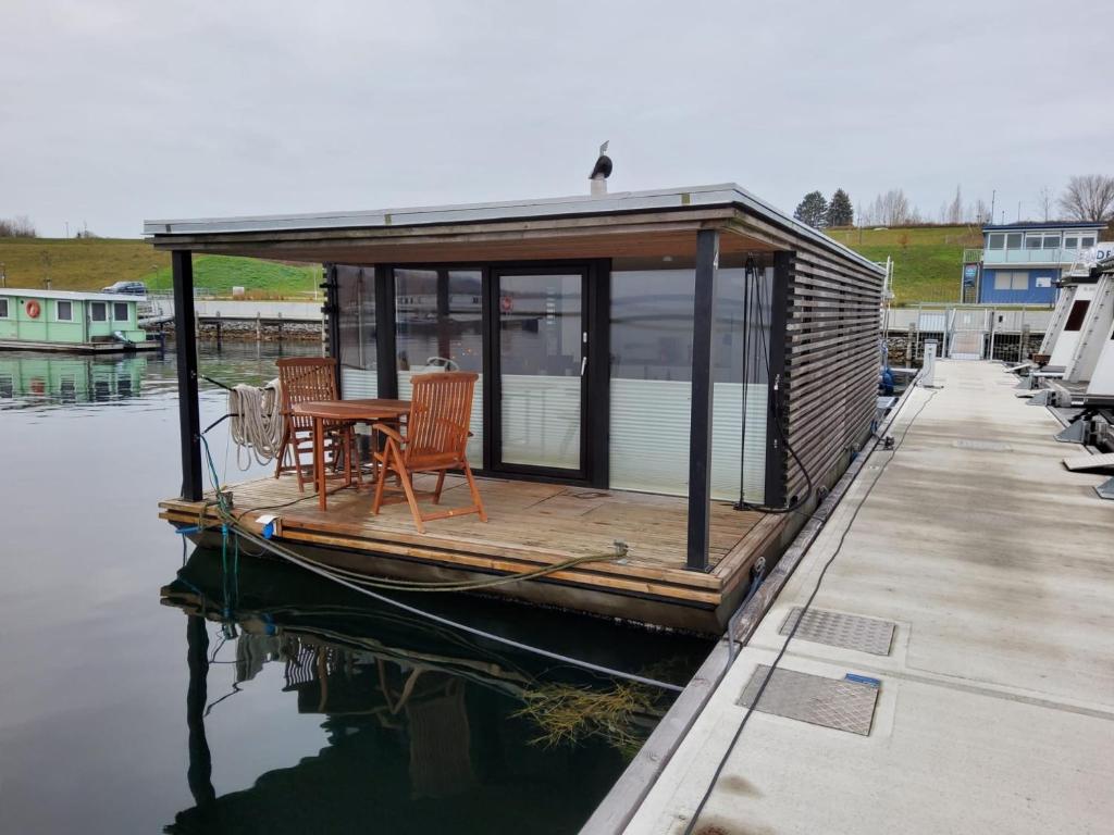 a house boat with a table and chairs on the water at Hausboot Geiselruh in Braunsbedra