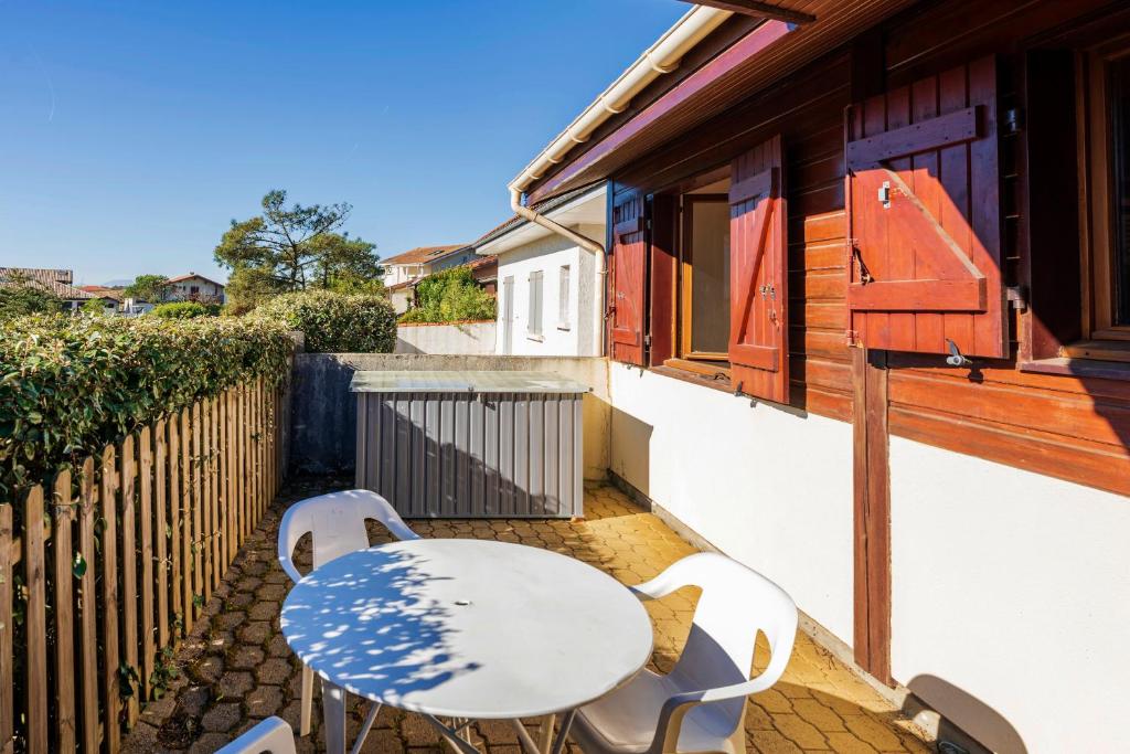 a patio with a table and chairs on a balcony at Chardons bleus - villa 6p in Capbreton