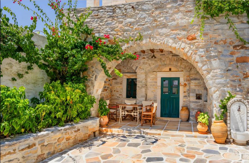 an entrance to a stone house with a green door at Zeus House in Naxos Chora