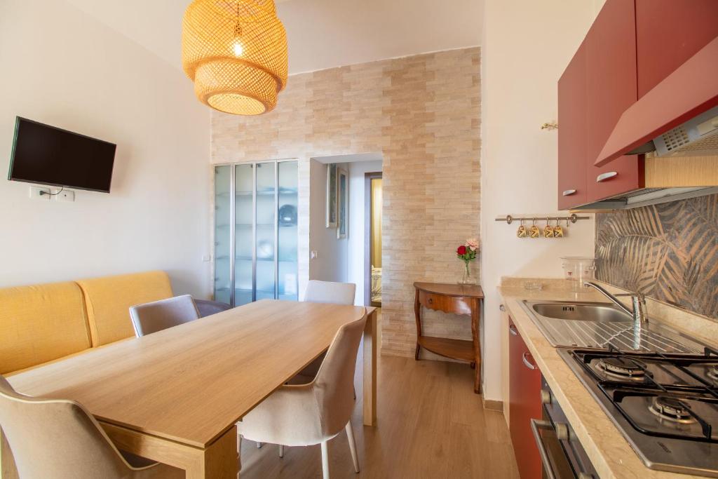 a kitchen with a wooden table and a dining room at Saija Apartment con piscina in Pozzallo